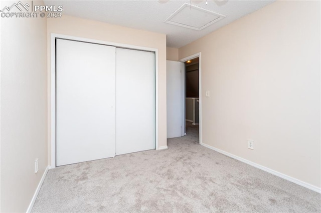 unfurnished bedroom featuring light colored carpet and a closet