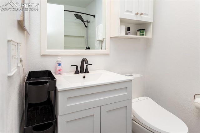 bathroom featuring vanity, toilet, and walk in shower