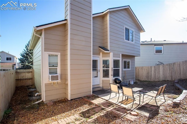 rear view of property featuring cooling unit and a patio area