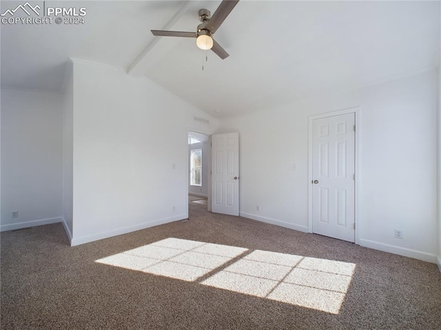 spare room featuring ceiling fan, lofted ceiling with beams, and dark colored carpet