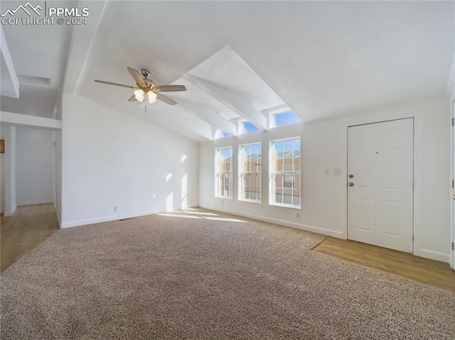 unfurnished living room with carpet flooring, vaulted ceiling with beams, and ceiling fan