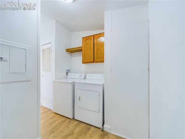 washroom featuring cabinets, light wood-type flooring, and separate washer and dryer