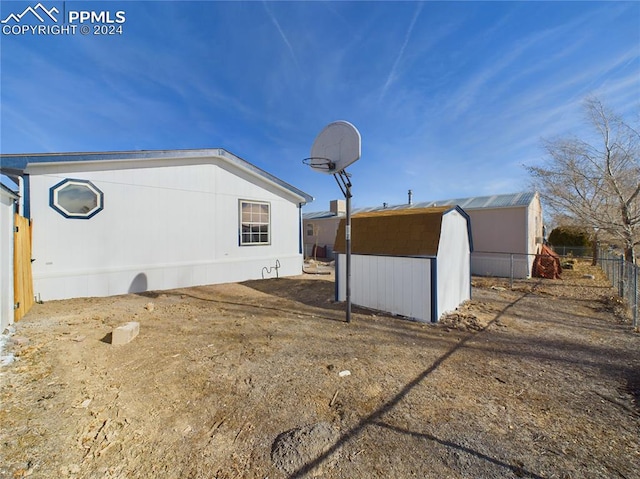 view of side of home with a storage shed