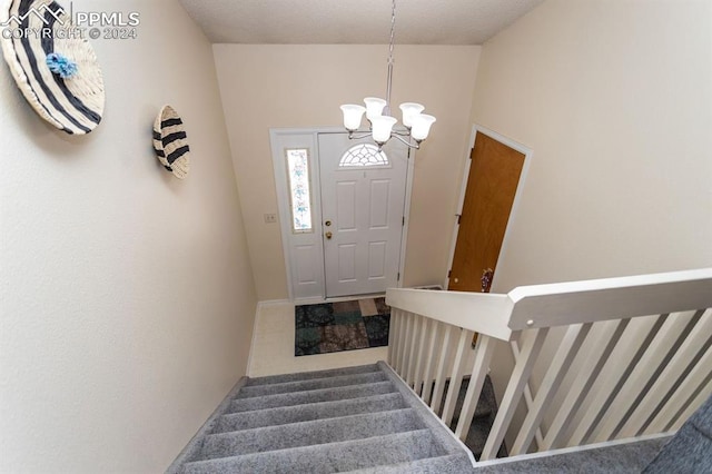 entrance foyer featuring carpet flooring and an inviting chandelier