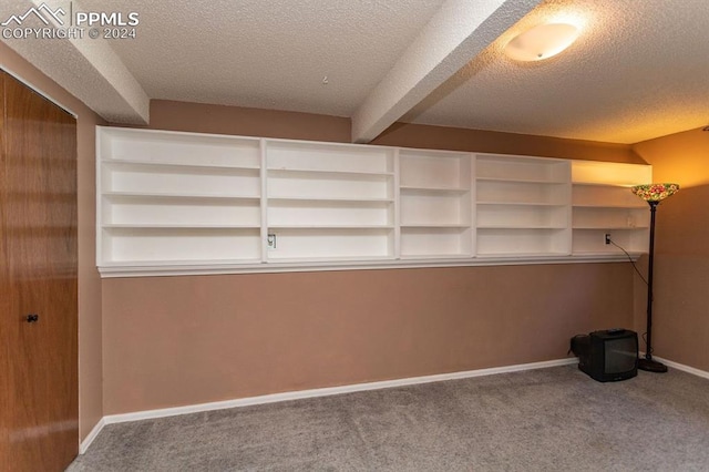 interior space with beam ceiling and a textured ceiling