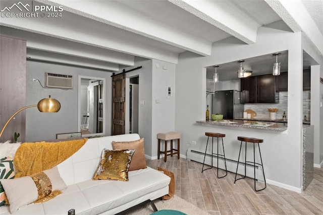 living room featuring a barn door, beam ceiling, a baseboard radiator, light hardwood / wood-style floors, and a wall unit AC