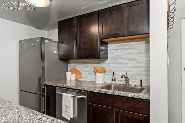 kitchen featuring tasteful backsplash, sink, stainless steel appliances, and dark brown cabinets