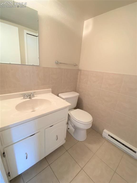 bathroom featuring tile patterned flooring, vanity, a baseboard radiator, and tile walls