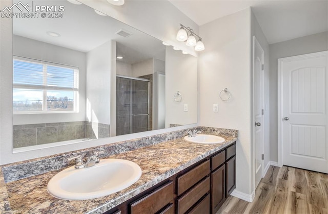 bathroom featuring hardwood / wood-style flooring, vanity, and an enclosed shower