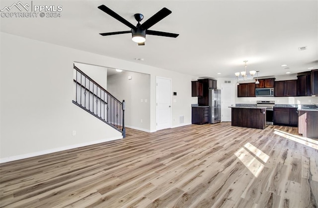 unfurnished living room with ceiling fan with notable chandelier, light hardwood / wood-style floors, and sink