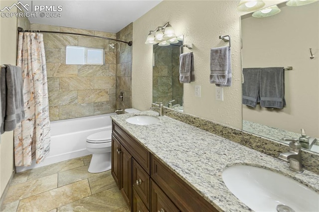 bathroom featuring shower / tub combo, a sink, toilet, and double vanity