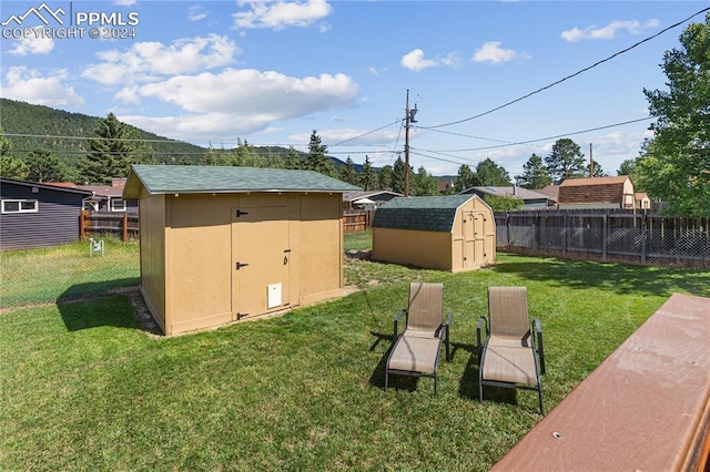 view of yard featuring an outdoor structure, a storage shed, and fence