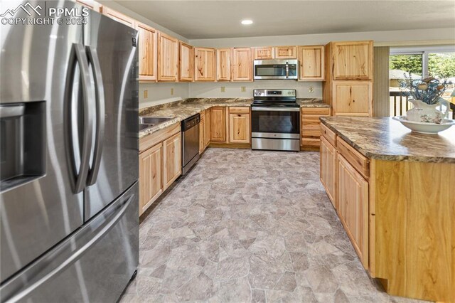 721 N Baldwin St, Woodland Park, CO 80863 - kitchen with appliances with stainless steel finishes, stone finish flooring, light brown cabinets, stone counters, and recessed lighting