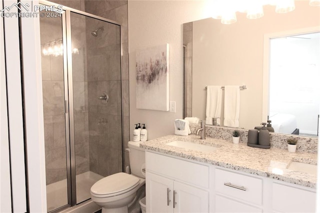 bathroom with vanity, a shower with shower door, and toilet