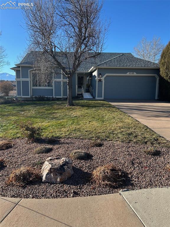 ranch-style home featuring a garage and a front lawn