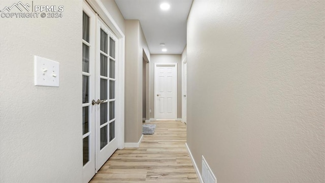 hall featuring light hardwood / wood-style floors and french doors