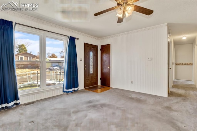 carpeted spare room featuring ceiling fan