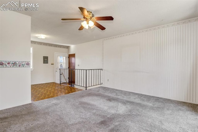 unfurnished room with electric panel, ceiling fan, carpet floors, and a textured ceiling