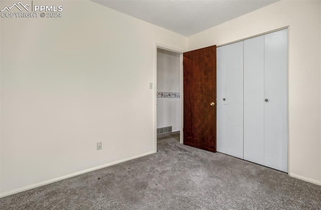 unfurnished bedroom featuring carpet floors and a closet