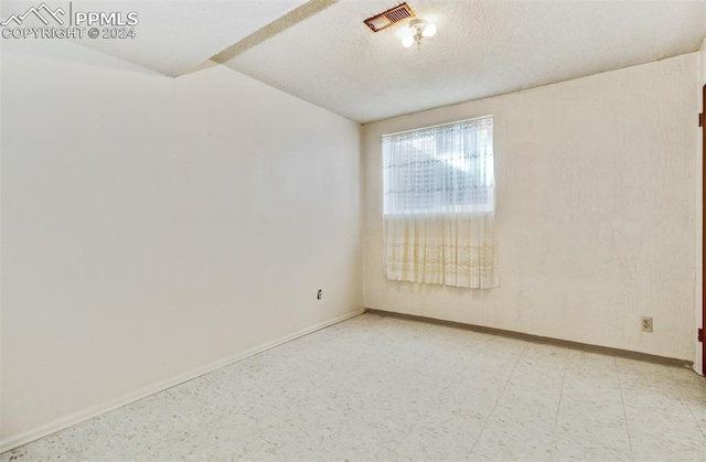 spare room with a textured ceiling