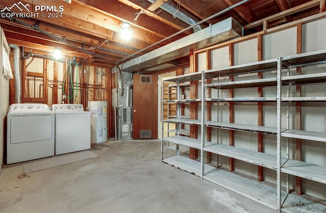 basement with heating unit, washer and dryer, and water heater