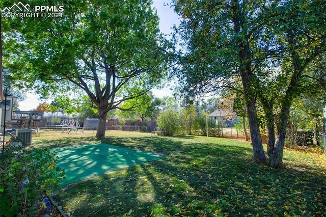 view of yard featuring a playground and central air condition unit