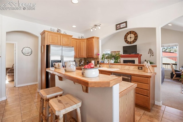 kitchen with backsplash, light tile patterned flooring, sink, and stainless steel appliances