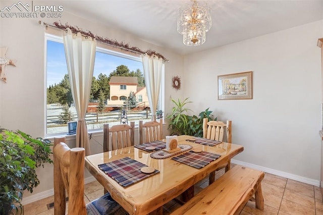 tiled dining space featuring a chandelier