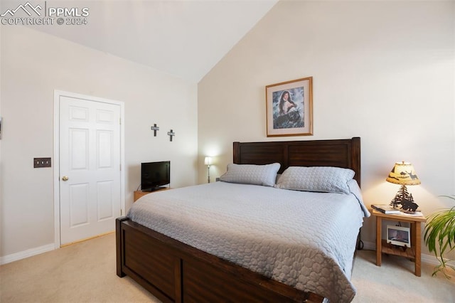 carpeted bedroom with high vaulted ceiling