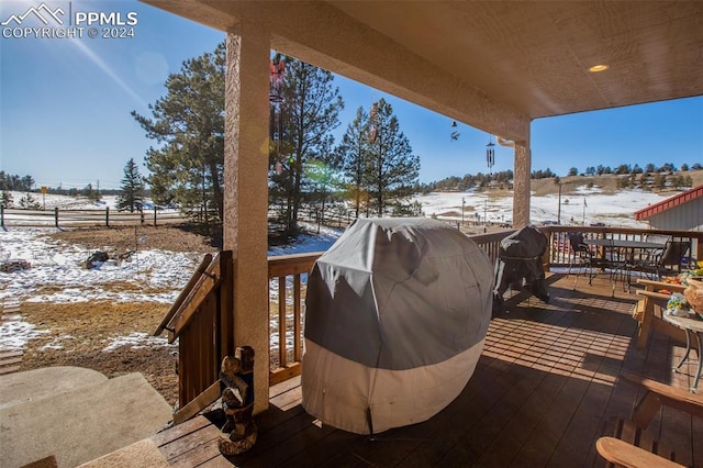 snow covered deck featuring area for grilling