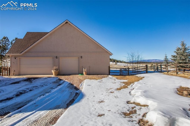 view of snow covered exterior with a garage