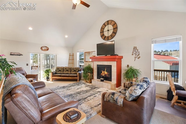 carpeted living room with high vaulted ceiling, ceiling fan, and a tile fireplace