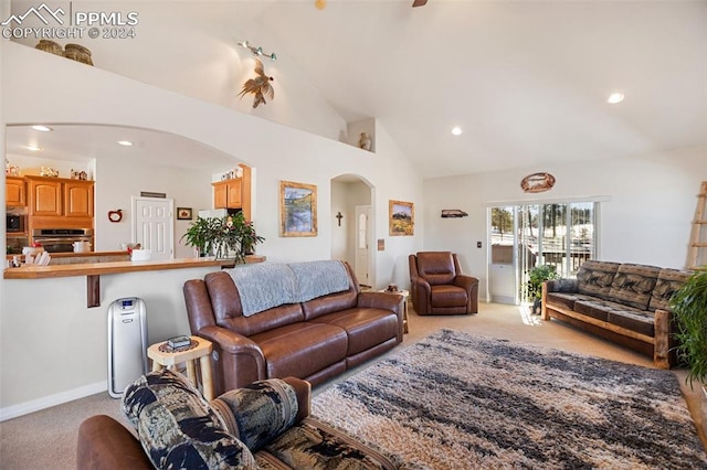 carpeted living room featuring high vaulted ceiling