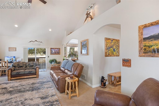 carpeted living room featuring ceiling fan and high vaulted ceiling