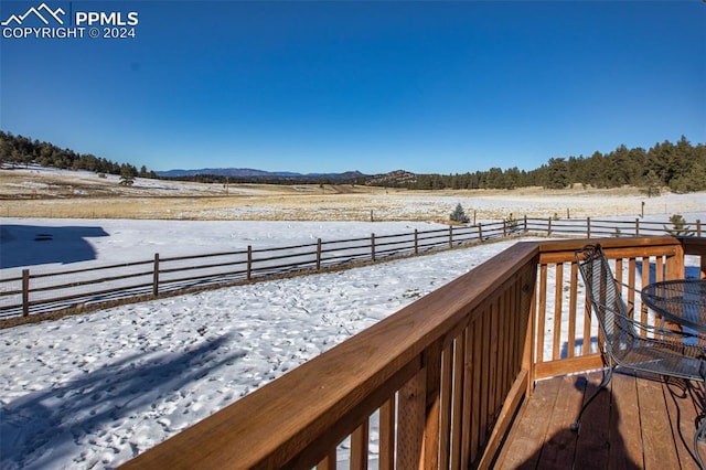 snow covered deck featuring a rural view