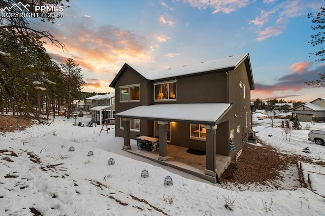 view of snow covered rear of property