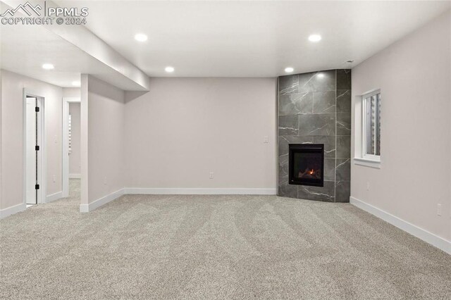 unfurnished living room featuring carpet flooring, a fireplace, and tile walls