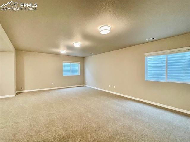 carpeted empty room featuring a textured ceiling