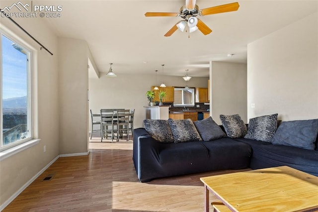 living room with dark hardwood / wood-style flooring, plenty of natural light, and ceiling fan