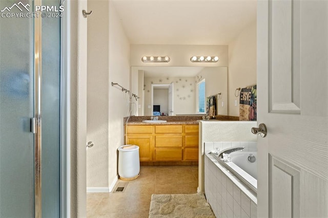 bathroom featuring tile patterned flooring, vanity, and separate shower and tub