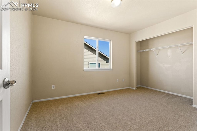 unfurnished bedroom featuring carpet flooring and a closet