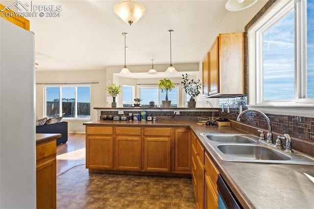 kitchen featuring sink, a healthy amount of sunlight, and decorative light fixtures