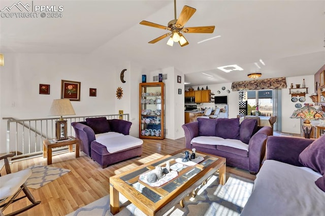 living room featuring ceiling fan, light wood-type flooring, and vaulted ceiling