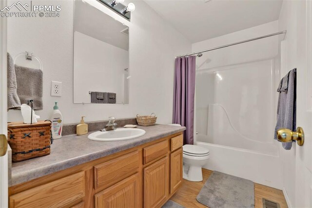 full bathroom with wood-type flooring, vanity, toilet, and shower / bathtub combination with curtain