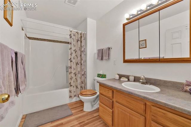 full bathroom with shower / tub combo, vanity, hardwood / wood-style flooring, and toilet