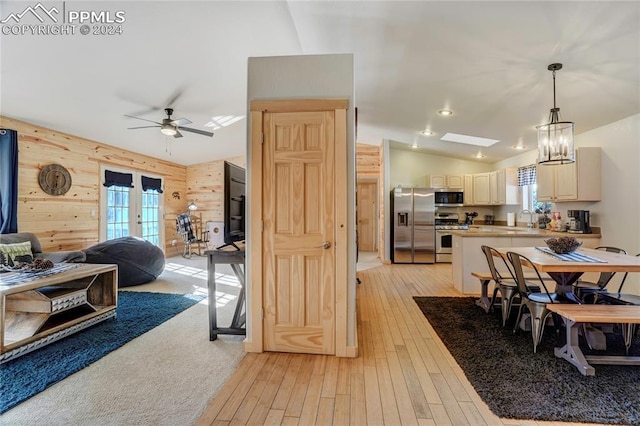 kitchen featuring lofted ceiling with skylight, plenty of natural light, decorative light fixtures, and appliances with stainless steel finishes