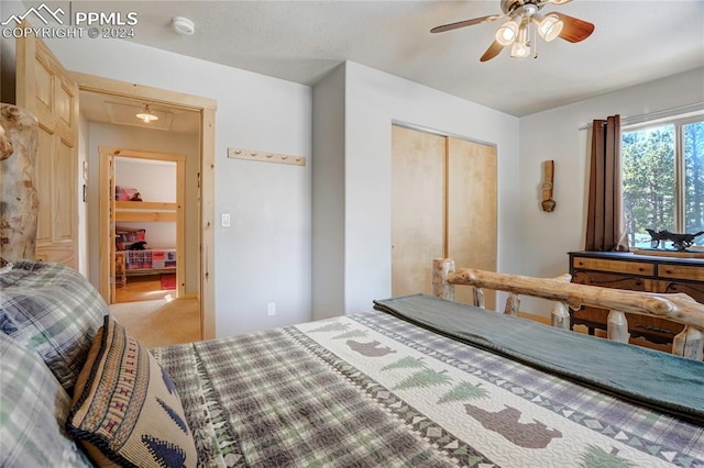 bedroom with ceiling fan, a closet, and light carpet