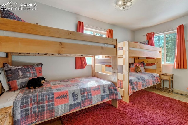 bedroom with multiple windows and light hardwood / wood-style flooring