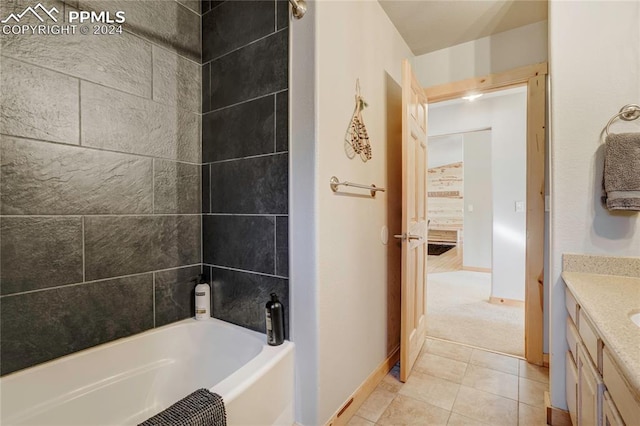 bathroom featuring tile patterned floors, vanity, and tiled shower / bath