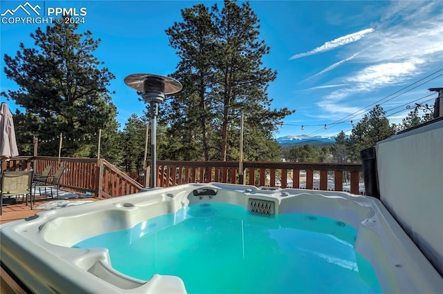 view of pool with a hot tub and a deck